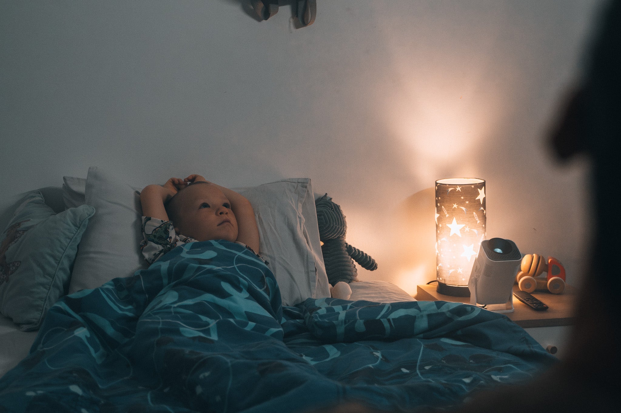 boy laying in bed watching Ozmotic Learning projector