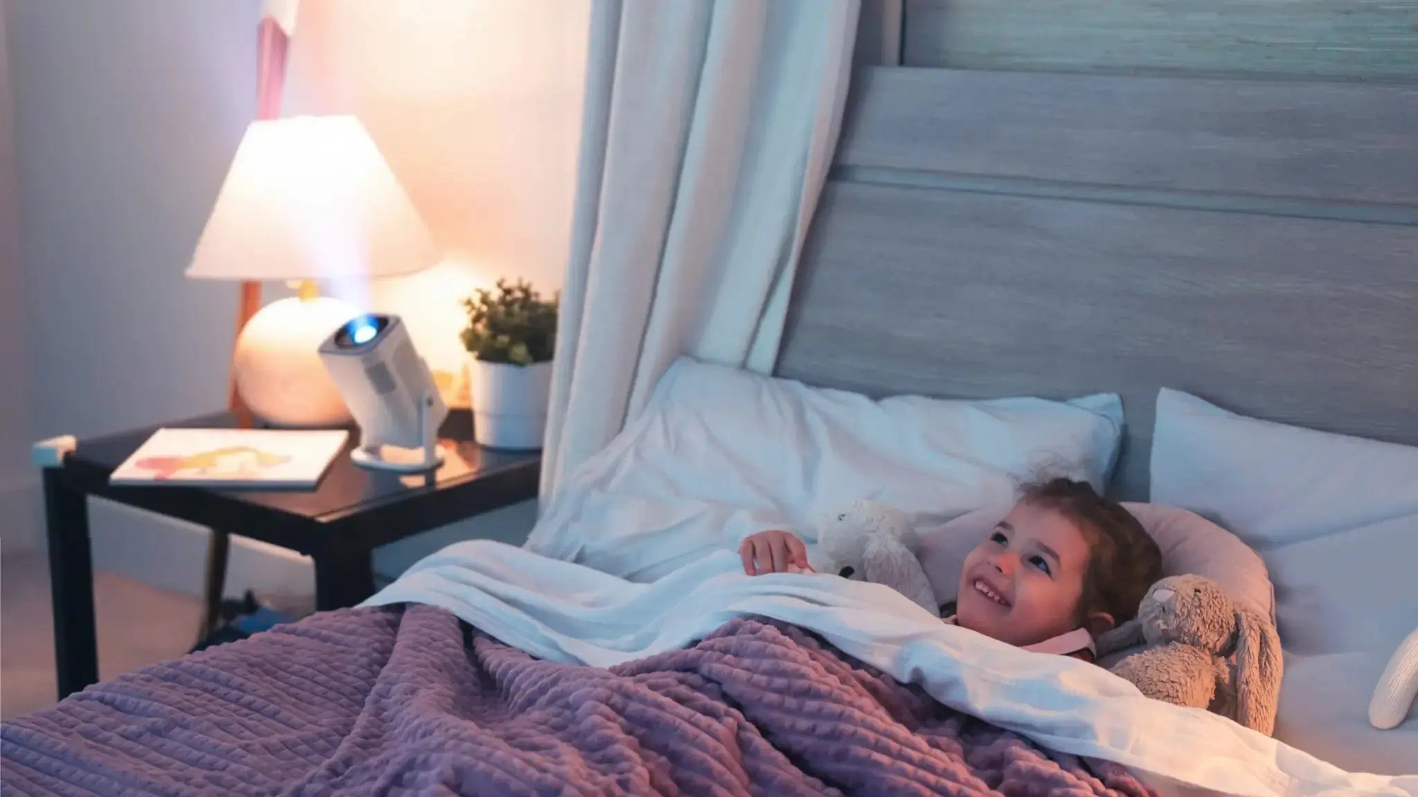 girl laying in bed watching Ozmotic Learning Projector