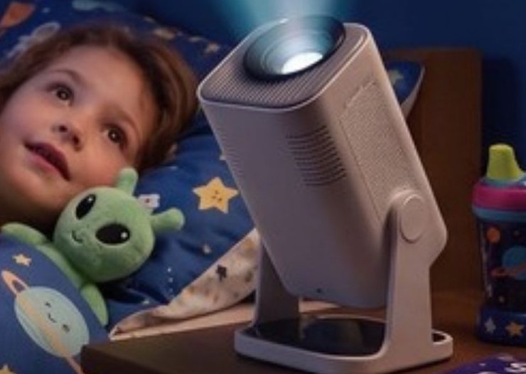 A child in star bedding watches the Ozmotic projector on the nightstand